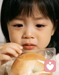 【看见，是比规矩更深的爱】
三岁的孩子眼眶含泪，手摸着面包却不敢拆开，懂事得让人心疼。
当孩子为了迎合大人的“规矩”，不得不压抑真实的渴望与委屈时，他正在学着构建一个“懂事”的假我来保护自己。
规矩固然重要，但如果长期只讲对错、不看情绪，孩子可能会逐渐失去表达真实自我的能力。
别让孩子在小小的年纪，就学会了孤独地消化悲伤。比起做一个“老成”的孩子，他更需要一个能看见他委屈、允许他哭泣的怀抱配图