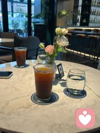 午间，在光线柔和的咖啡馆落座。
冰美式清苦回甘，桌上小花静静舒展，把浮躁都轻轻抚平。

作为倾听师，我总偏爱这样松弛的角落。
不被喧嚣打扰，不被节奏裹挟，让自己先安顿下来，才能接住你藏在心底的情绪。

不必急于奔赴生活，如果你累了、迷茫了，随时可以来聊聊。
我在这里，带着耐心与温柔，等你慢慢开口。✨配图