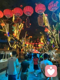 柳青灯树祈福赋！
 
津门杨柳青古陌，夜色垂空，长衢铺锦。千树缀灯，繁光错落，朱红祈愿绦带缠枝，彩盏玲珑悬于枝杪，流辉漫染青砖巷陌。
 
瞻彼嘉树，枝分万缕，一绳一笺，皆藏游人寸心。朱帛垂垂，书世间期许；花灯灼灼，映眼底温柔。往来行客驻足瞻望，或抬眸轻诉心事，或静立安敛愁怀。平日缠身之焦虑、郁结于心之烦忧，遇此满树柔光，皆徐徐消融。
 
树承人间万般祈愿，灯载众生细碎温柔。不必求仙问道以解心扰，只凭一巷灯火、满枝祈语，便可抚慰浮躁灵魂。光影流转之间，人心自归平和；红绦轻摇之际，执念渐作轻烟。
 
儒者观此，知寻常烟火最能安身；道者观此，悟心绪当如灯影舒展；释者观此，明接纳自身烦忧便是解脱。如柳七流连市井，不困于俗世桎梏，乐于观览人间烟火温柔，以平和之心接纳众生心事，以眼底温柔传递治愈力量。
 
灯树无言，却收纳万千心绪；古巷无声，可容纳所有悲欢。人立光下，与满枝期许对望，方知治愈从来不在远途，只在眼前这一片人间暖色。愿执灯树下之人，皆可卸下心头重担，存一份松弛自在，携一身清宁归途，岁岁常安，万事纾怀。配图