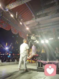 古戏台灯辉错落，伶人踏台献技。巧身旋跃环圈之间，身姿柔韧似风拂垂柳，腾转轻盈若月下惊鸿。每一回腾空、每一次舒身，皆藏经年磨砺的定力。台下观者屏息静赏，俗世焦虑随灵动身姿缓缓消散。以一身柔韧对抗岁月辛劳，凭从容气韵安抚人心烦扰，这般坚韧温婉，兼具风骨与温柔，一眼治愈满场奔波倦客，人间烟火里最动人的力量。配图