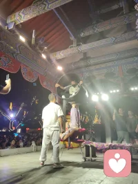 古戏台灯辉错落，伶人踏台献技。巧身旋跃环圈之间，身姿柔韧似风拂垂柳，腾转轻盈若月下惊鸿。每一回腾空、每一次舒身，皆藏经年磨砺的定力。台下观者屏息静赏，俗世焦虑随灵动身姿缓缓消散。以一身柔韧对抗岁月辛劳，凭从容气韵安抚人心烦扰，这般坚韧温婉，兼具风骨与温柔，一眼治愈满场奔波倦客，人间烟火里最动人的力量。配图