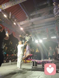 古戏台灯辉错落，伶人踏台献技。巧身旋跃环圈之间，身姿柔韧似风拂垂柳，腾转轻盈若月下惊鸿。每一回腾空、每一次舒身，皆藏经年磨砺的定力。台下观者屏息静赏，俗世焦虑随灵动身姿缓缓消散。以一身柔韧对抗岁月辛劳，凭从容气韵安抚人心烦扰，这般坚韧温婉，兼具风骨与温柔，一眼治愈满场奔波倦客，人间烟火里最动人的力量。配图