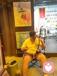 津沽柳青古肆纵横，诸业匠人栖于巷陌。抚弦者拉胡叙温，烹食者烟火暖心，手作铺藏细碎风雅。众人奔走谋生，却以技艺予过客松弛慰藉。谋生与治愈两相相融，烟火生计抚平尘世焦虑，平凡坚守藏温柔力量，往来游人皆被这人间赤诚缓缓疗愈。配图