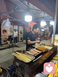津沽柳青古肆纵横，诸业匠人栖于巷陌。抚弦者拉胡叙温，烹食者烟火暖心，手作铺藏细碎风雅。众人奔走谋生，却以技艺予过客松弛慰藉。谋生与治愈两相相融，烟火生计抚平尘世焦虑，平凡坚守藏温柔力量，往来游人皆被这人间赤诚缓缓疗愈。配图