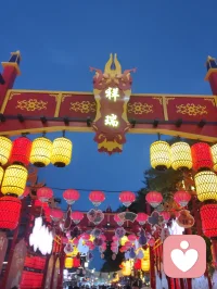 杨柳青古镇门楼巍然，石狮静立两侧，满巷灯笼连成金色灯海。心理学认为，规整温暖的传统场景可稳定涣散心绪，厚重石雕带来踏实的安定感。行走于灯火之下，视线被连片柔光包裹，繁杂思虑慢慢沉淀，古街灯火是抚慰焦虑、安放自我的天然疗愈场。配图