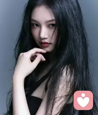 黑发散落在肩侧，指尖轻抵下颌，在沉静的灰调里，藏着不张扬的温柔与力量。配图