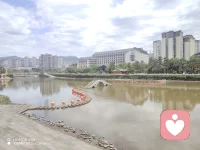 藏在山水间的小城，总有让人一眼心动的风景。
沿着河岸漫步，眼前的画面太治愈了：澄澈的河水绕城而过，蜿蜒的汀步石桥横跨水面，一串串红灯笼点缀其间，成了河上最亮眼的风景。对岸，现代高楼拔地而起，与远处的青山遥遥相对，传统的亭台楼阁藏在绿树间，新旧交融，烟火与诗意共生。
风里带着春日的温柔，河水漾着细碎的波光，走在河畔，每一步都像是踩在画里。在这里，不用追赶时间，只需要慢慢走，慢慢看，看小城的日出日落，看河水的四季流淌，感受这份独属于山水小城的松弛与美好。