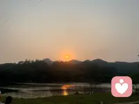 🌿 「今天的日落，像一次无声的心理咨询。
它没有急着给出答案，只是慢慢沉进山的轮廓里，把一天的褶皱，都铺成水面的碎光。
我们总说要“快点好起来”，可就像太阳不用急着落下，情绪也不必急着被“修正”。
它只是在慢慢流动，就像湖面的光，会暗下去，也会再亮起来。
今天也辛苦啦，和这轮落日一起，和自己和解一小会儿吧。
#倾听#心理#自然疗愈配图